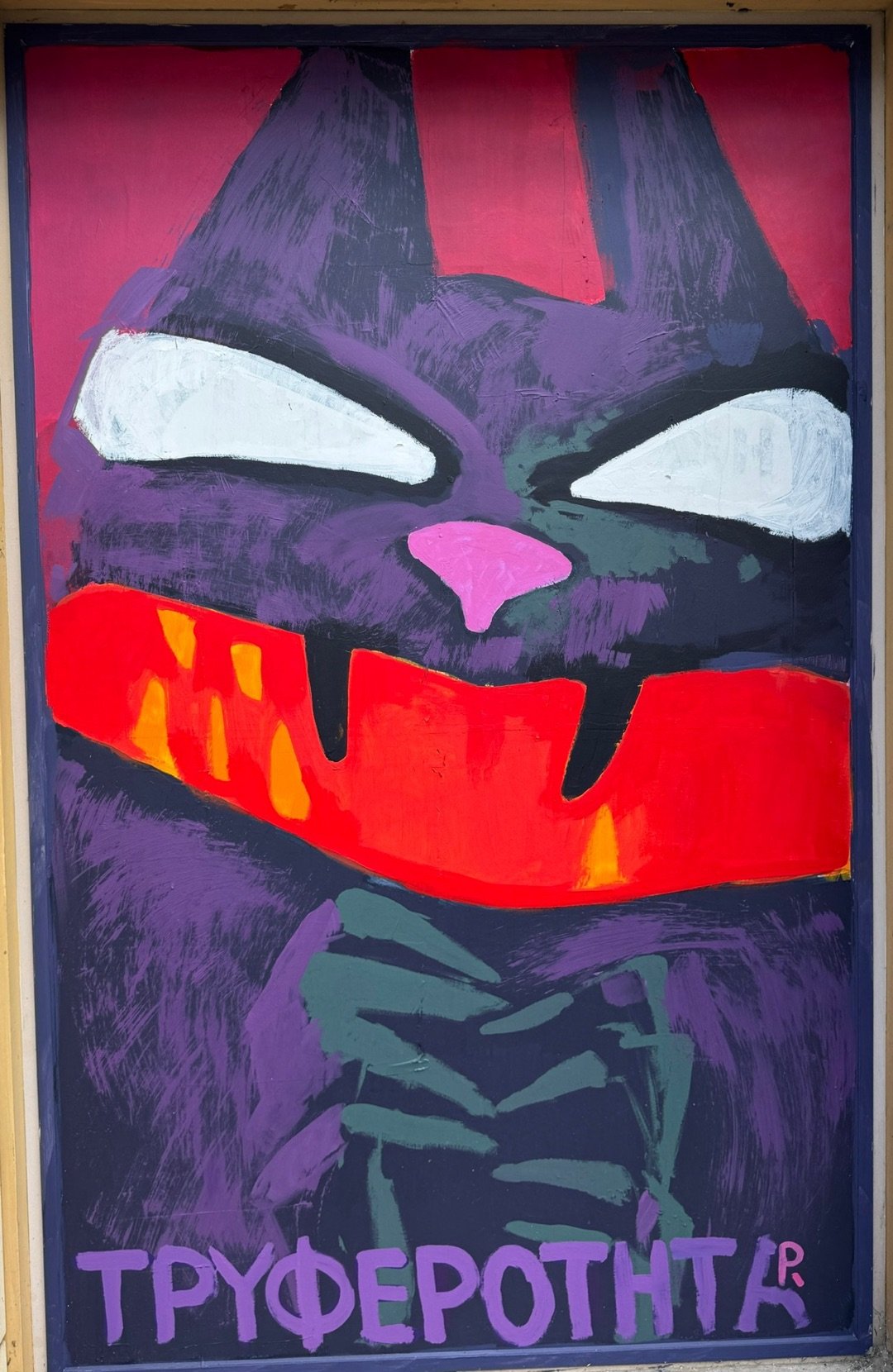 Purple cat with white eyes and a wide red grin over clasped green hands, with the Greek word ΤΡΥΦΕΡΟΤΗΤΑ (tenderness)